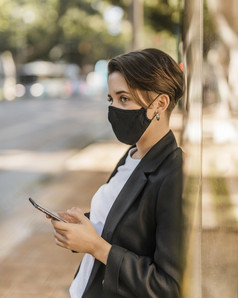 女人与医疗面具检查她的电话