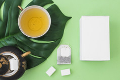 白色盒子Herbal茶糖多维数据集茶袋绿色纸背景