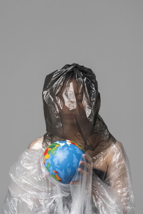 女人持有地球全球而被覆盖塑料