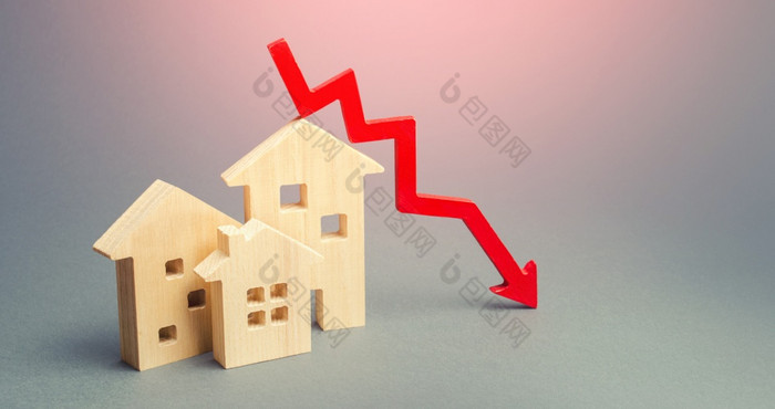微型木房子和红色的箭头下来的概念低成本真正的房地产较低的抵押贷款感兴趣利率下降价格为租赁住房和公寓减少需求为首页购买