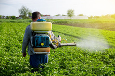 农民与雾雾化器喷雾器喷雾杀真菌剂和农药土豆灌木有效的作物保护环境影响保护培养植物从昆虫和真菌感染