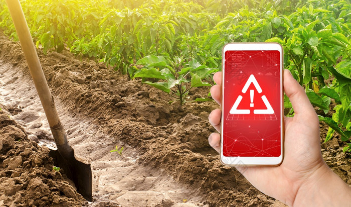 电话和警告标志的背景胡椒种植园和灌溉通道与铲有害的农药和化学物质农业环境危害塑料微粒的作物