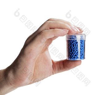 男人。持有小容器与蓝色的塑料颗粒使用为制造业