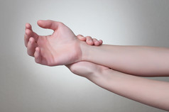 年轻的女人触碰她的痛苦的手腕