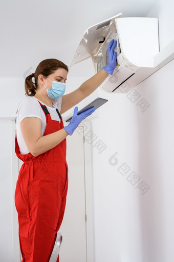 女技术员使用数字平板电脑和修复空气护发素在室内女技术员使用数字平板电脑和修复空气护发素