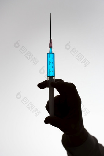 轮廓的手女医生与注射器填满与蓝色的液体疫苗接种概念轮廓的手医生与注射器填满与蓝色的液体疫苗接种概念