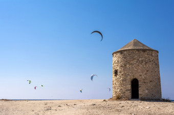 贴水Ioannis海滩莱夫卡斯岛希腊色彩斑斓的权力风筝跨度在的天空从风筝冲浪贴水Ioannis首页一些老风车贴水Ioannis海滩莱夫卡斯岛希腊