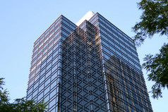 运动蓝色的天空与照亮反映了玻璃外观现代办公室建筑