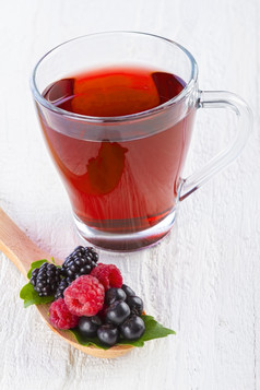 水果红色的茶与野生浆果木勺子白色木表格