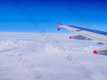 视图从飞机窗口飞机翼在云和蓝色的天空旅行空气飞机飞行以上地球axbcaxbf