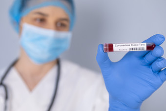 护士持有测试管与积极的冠状病毒测试血样本病毒测试和研究概念焦点血测试管