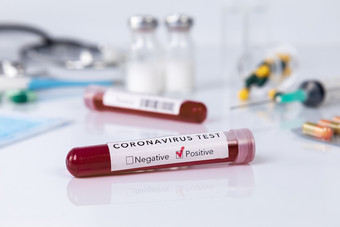 血测试管与的冠状病毒疾病为病毒测试和研究血测试管与保护面具药物温度计听诊器和注射器白色背景