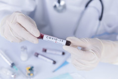 医生手与保护手套持有科维德冠状病毒测试血病毒测试和研究概念