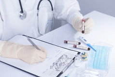 医生手与保护手套持有科维德冠状病毒测试血使统计笔记病毒测试和研究概念焦点新冠病毒测试