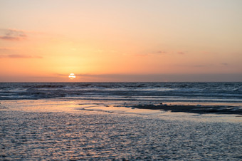 日落海滩海洋日落海滩而且海洋与沙子沙丘而且云