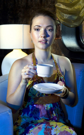 女人坐着扶手椅而且喝茶餐厅