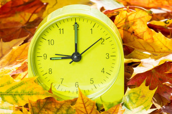 报警时钟秋天叶子时间改变概念秋天改变时钟一个小时回来