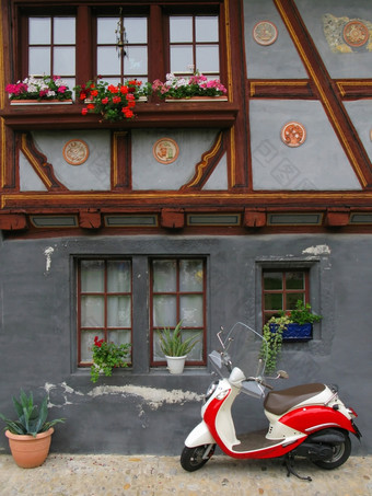时尚的机动脚踏两用车对老建筑弗里堡瑞士