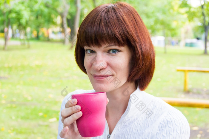 照片女人与棕色（的）头发喝茶