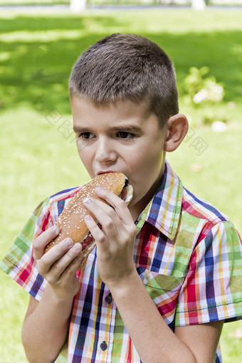 可爱的浅黑肤色的女人男孩<strong>吃热狗</strong>与食欲可爱的浅黑肤色的女人男孩<strong>吃热狗</strong>