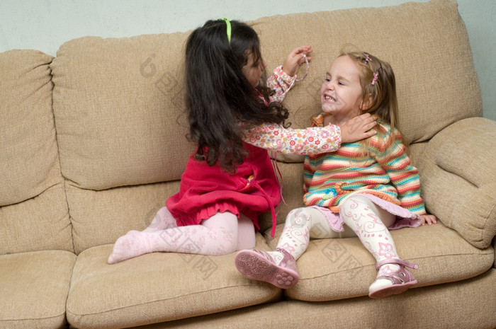 两个小女孩相互冲突的而且尝试战斗两个小女孩相互冲突的