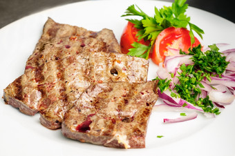 炸牛肉猪肉肝与新鲜的蔬菜沙拉服务板炸牛肉肝与蔬菜