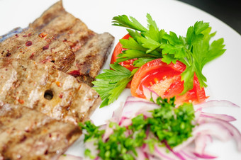 炸牛肉猪肉肝与新鲜的蔬菜沙拉服务板炸牛肉肝与蔬菜