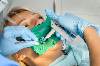牙医工作与病人考试清洁固化使用牙科水飞机