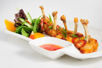炸辣椒鸡翅膀与蔬菜沙拉和热酱汁炸辣椒鸡翅膀