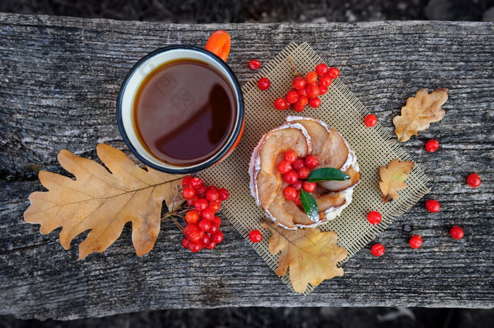 浪漫的秋天仍然生活与篮子蛋糕杯茶罗文浆果和叶子木董事会前视图浪漫的秋天仍然生活