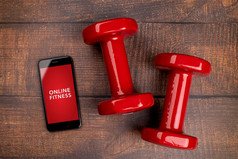 红色的哑铃和智能手机伍丹背景应用程序为培训在室内在线健身程序首页在线锻炼前视图新冠病毒冠状病毒检疫概念在线健身程序