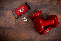 红色的哑铃和智能手机伍丹背景应用程序为培训在室内在线健身程序首页在线锻炼前视图新冠病毒冠状病毒检疫概念在线健身程序
