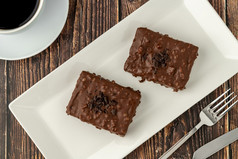 巧克力覆盖葡萄干蛋糕木表格与过滤器咖啡
