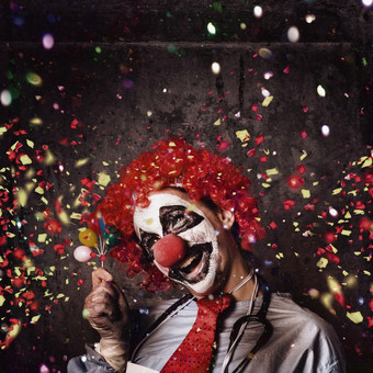 疯狂的马戏团小丑与微笑持有微型气球下下降五彩纸屑在生日聚会，派对庆祝活动医院病房