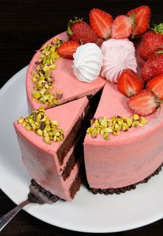 减少一块巧克力草莓摩丝蛋糕装饰与浆果蛋白酥皮和开心果