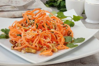胡萝卜丝带沙拉沐浴与酸奶沙拉酱经验丰富的与炸坚果和芝麻种子新鲜的香菜