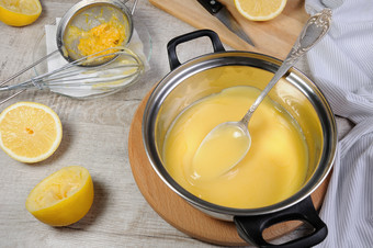 新鲜准备柠檬库尔德人蛋奶沙司水果汁平底锅搅拌与勺子