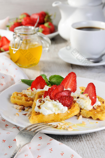 精致的融化令人馋涎欲滴的比利时华夫饼与生奶油草莓味与花生和蜂蜜什么可以更好的为早餐