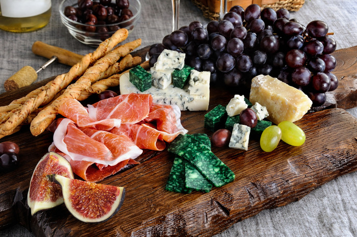 菜为零食antipasto木董事会与火腿不同的类型奶酪葡萄和无花果表格与酒