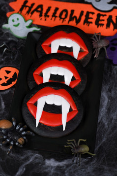 吸血鬼尖牙突出的从朱红色嘴唇上釉蜂蜜姜饼饼干万圣节食物的想法