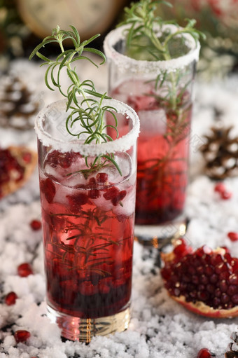 玻璃与石榴丽塔·哈与蜜饯小红莓迷迭香完美的鸡尾酒为圣诞节聚会，派对