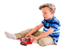 小男孩戏剧与红色的玩具车白色背景