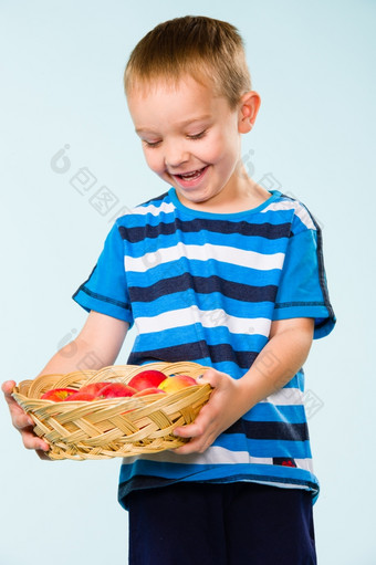 小男孩条纹t恤水果篮子工作室拍摄而且光蓝色的背景