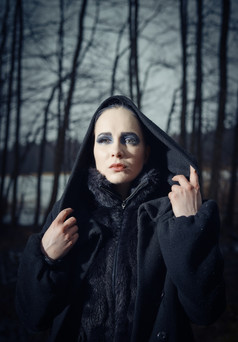时尚女人穿冬天外套而且她构成悲观的森林冷多雨的天气交叉加工过的图像特写镜头