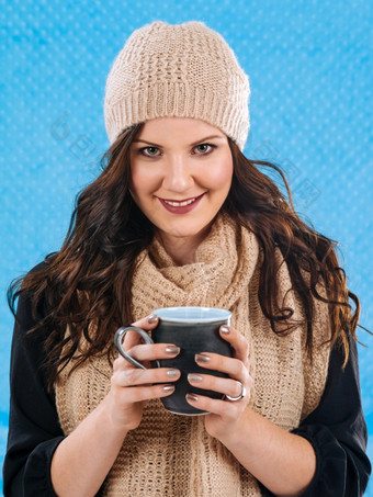 照片美丽的浅黑肤色的女人包装温暖的围巾而且帽子喝热咖啡热巧克力