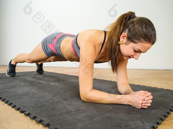 照片美丽的年轻的女人锻炼和做肘<strong>板材</strong>加强她的胃肌肉