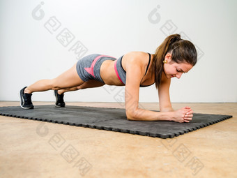 照片美丽的年轻的女人锻炼和做肘<strong>板材</strong>加强她的胃肌肉