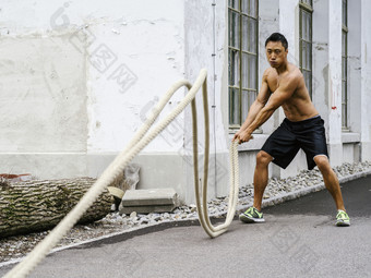 照片肌肉<strong>发</strong>达的亚洲男人。工作出与培训<strong>绳</strong>子外健身培训在户外与<strong>绳</strong>子