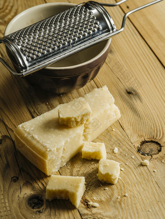 块<strong>帕尔玛</strong>奶酪木表格与刨丝器的背景