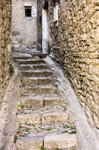 狭窄的小巷Gordes普罗旺斯法国有只是足够的空间为步骤而且两个小排水沟风之间的建筑